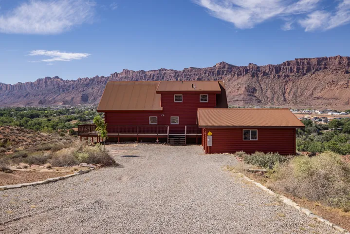 Red-sided residence with a brown roof and an attached deck