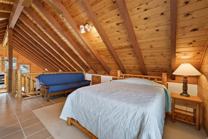 Angled wood-paneled ceiling with exposed beams