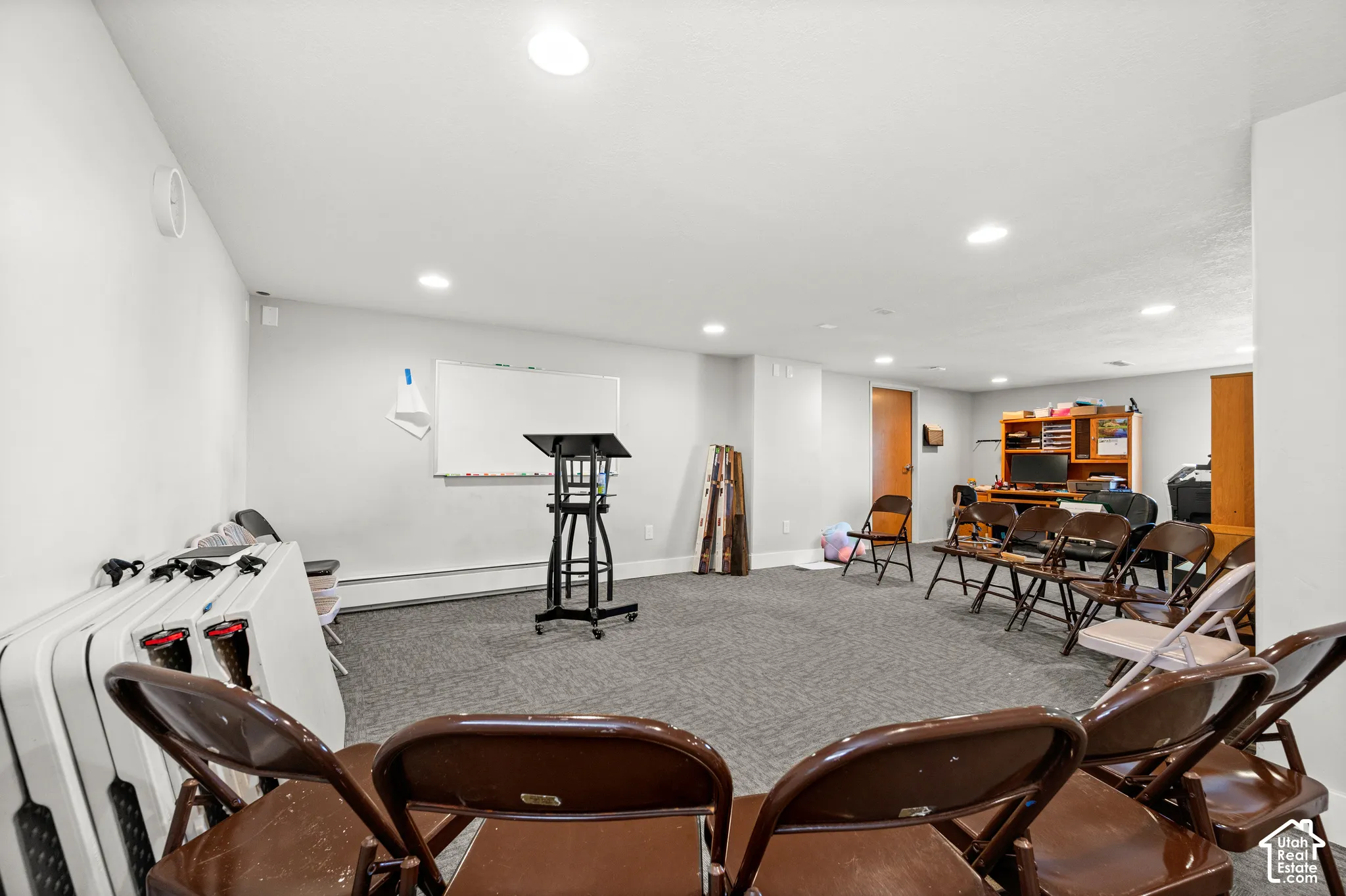 Spacious room with gray carpeting and recessed lighting