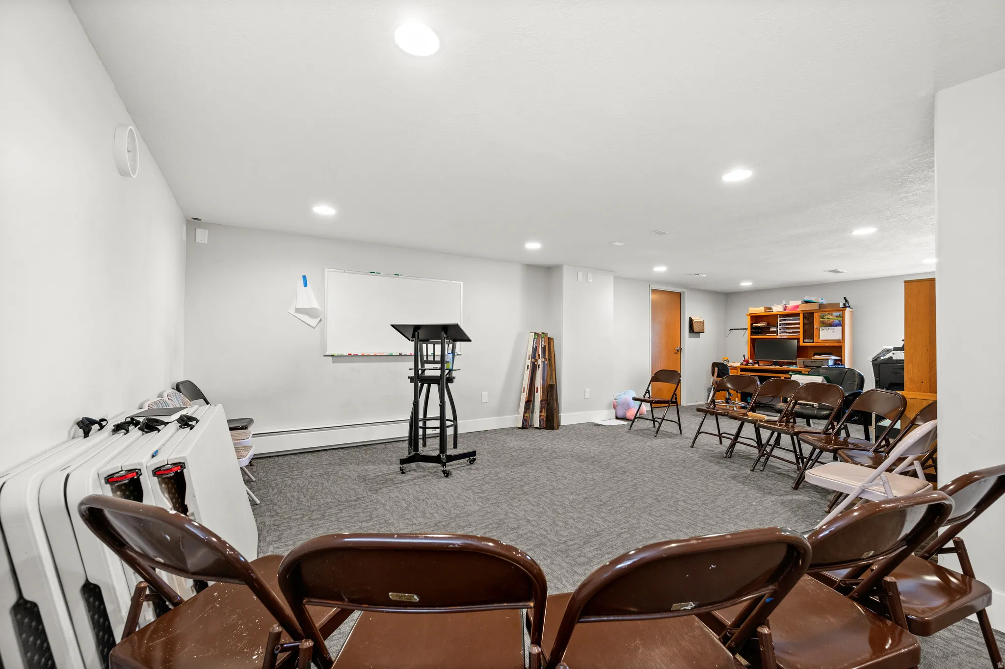 Spacious room with gray carpeting and recessed lighting