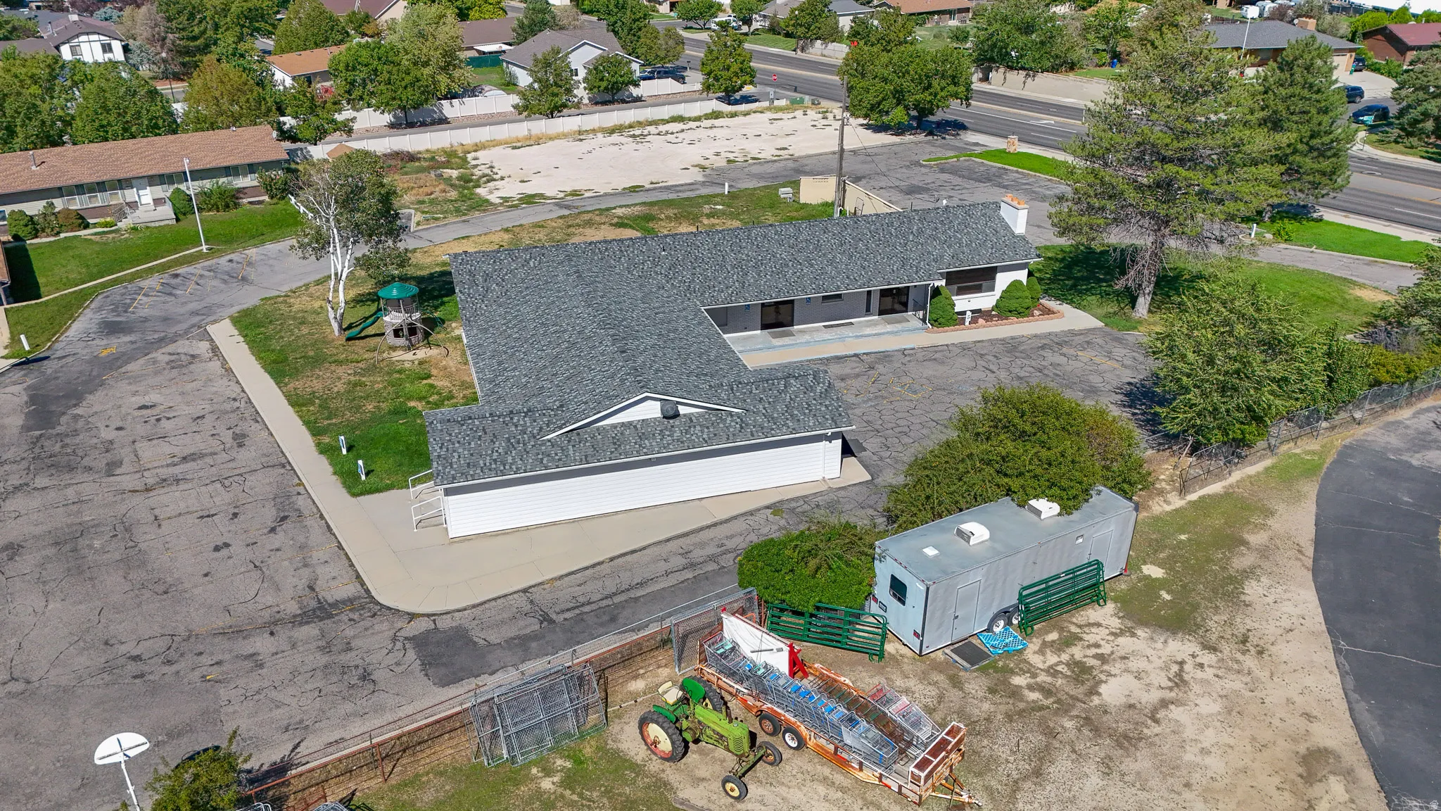 L-shaped single-story structure with a dark shingle roof and white exterior siding