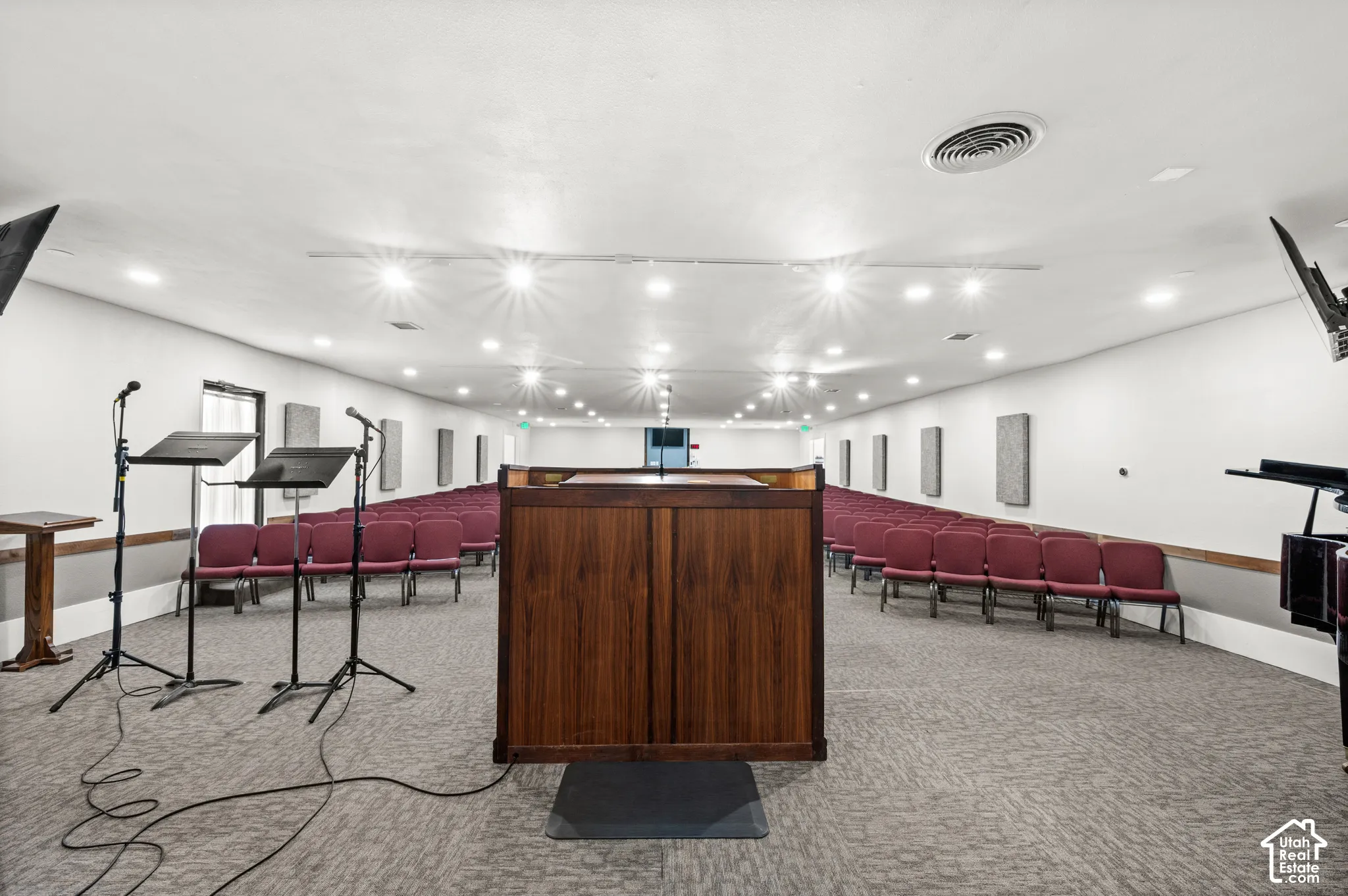Spacious interior with recessed lighting, textured carpet flooring, and integrated wall panels