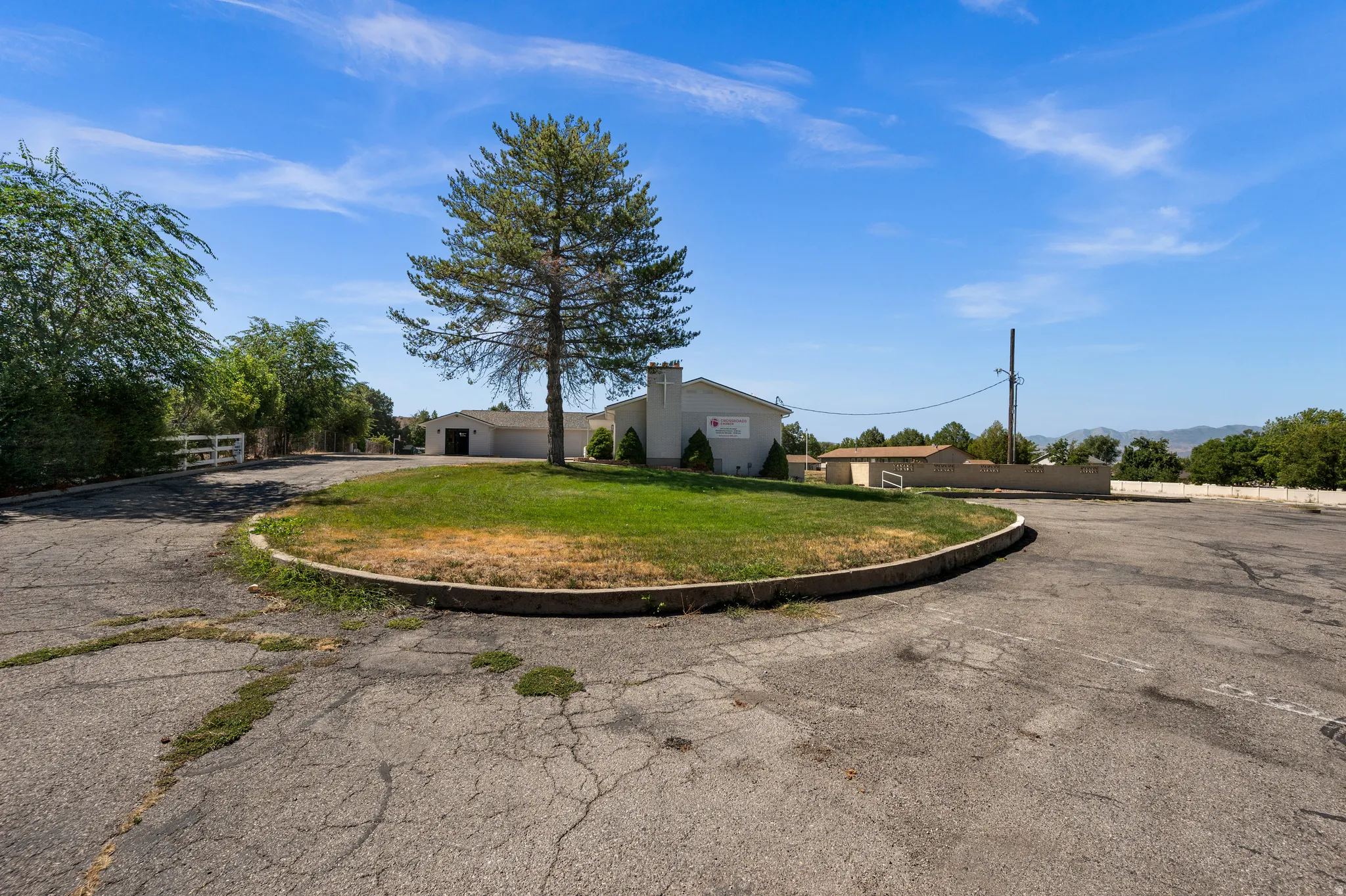Paved parking area with a central landscaped island and mature trees