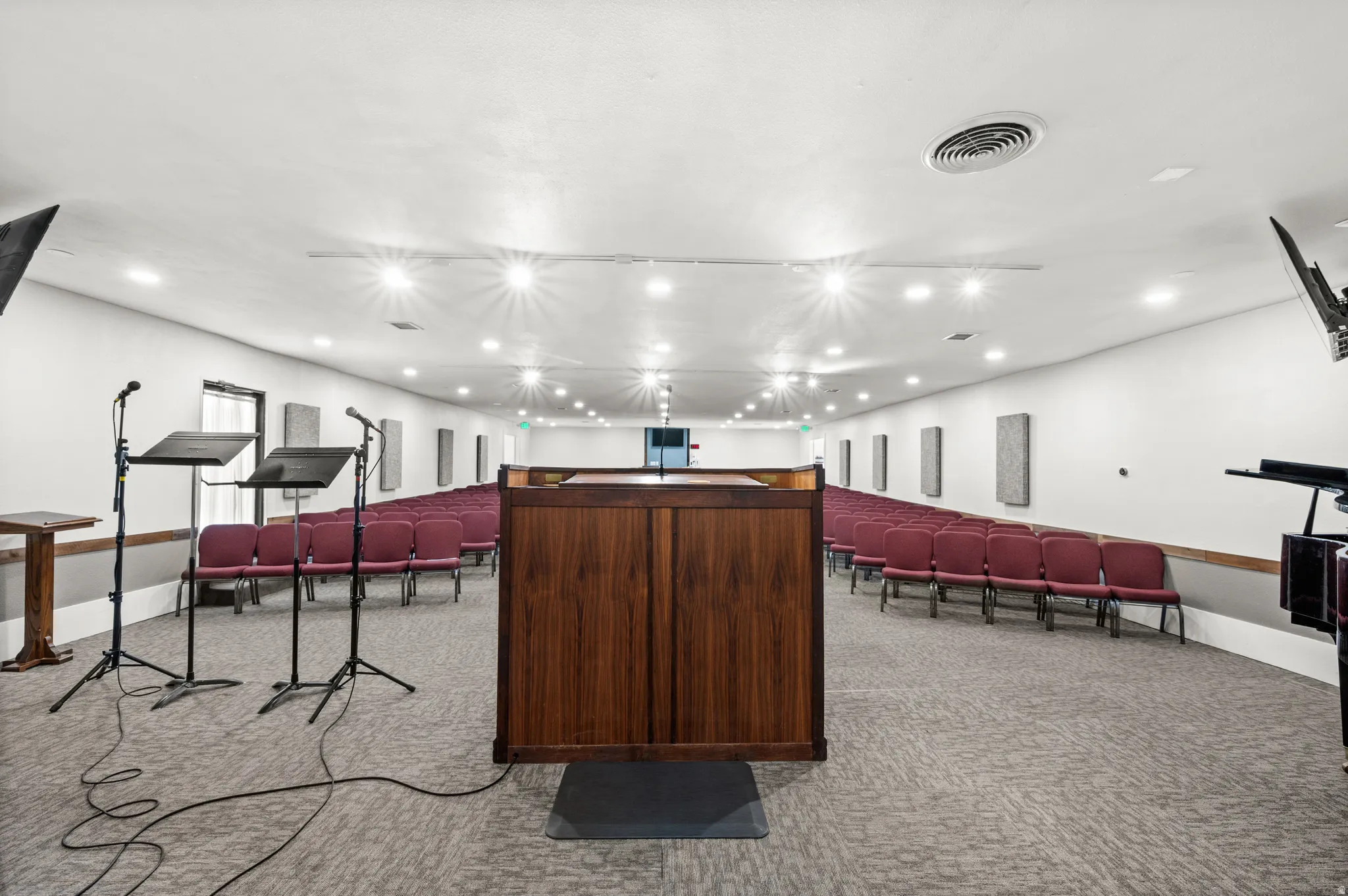 Spacious interior with recessed lighting, textured carpet flooring, and integrated wall panels