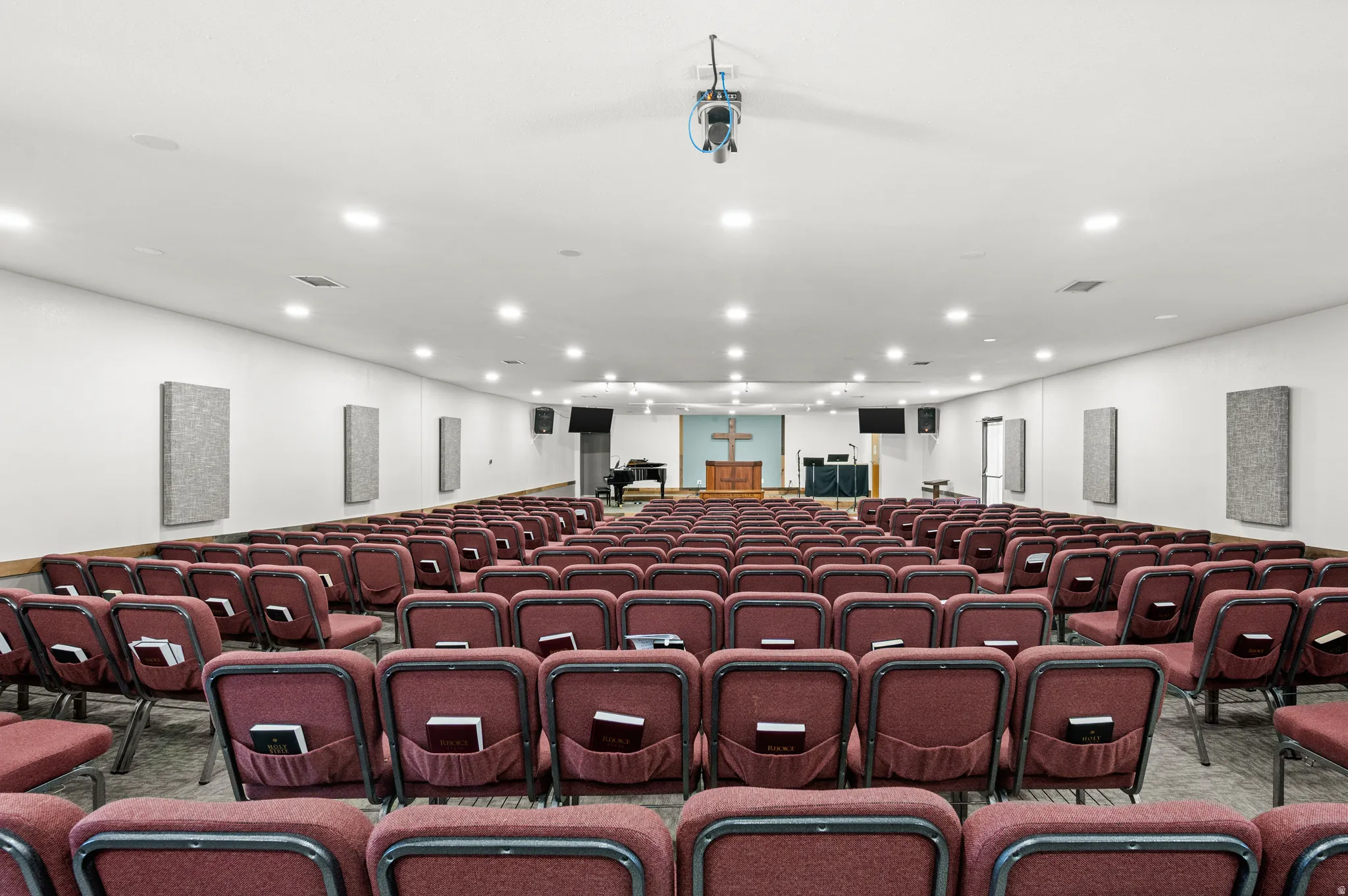 Spacious room with recessed lighting and wall-mounted acoustic panels