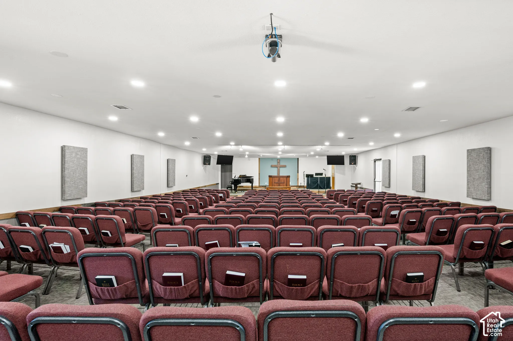 Spacious room with recessed lighting and wall-mounted acoustic panels