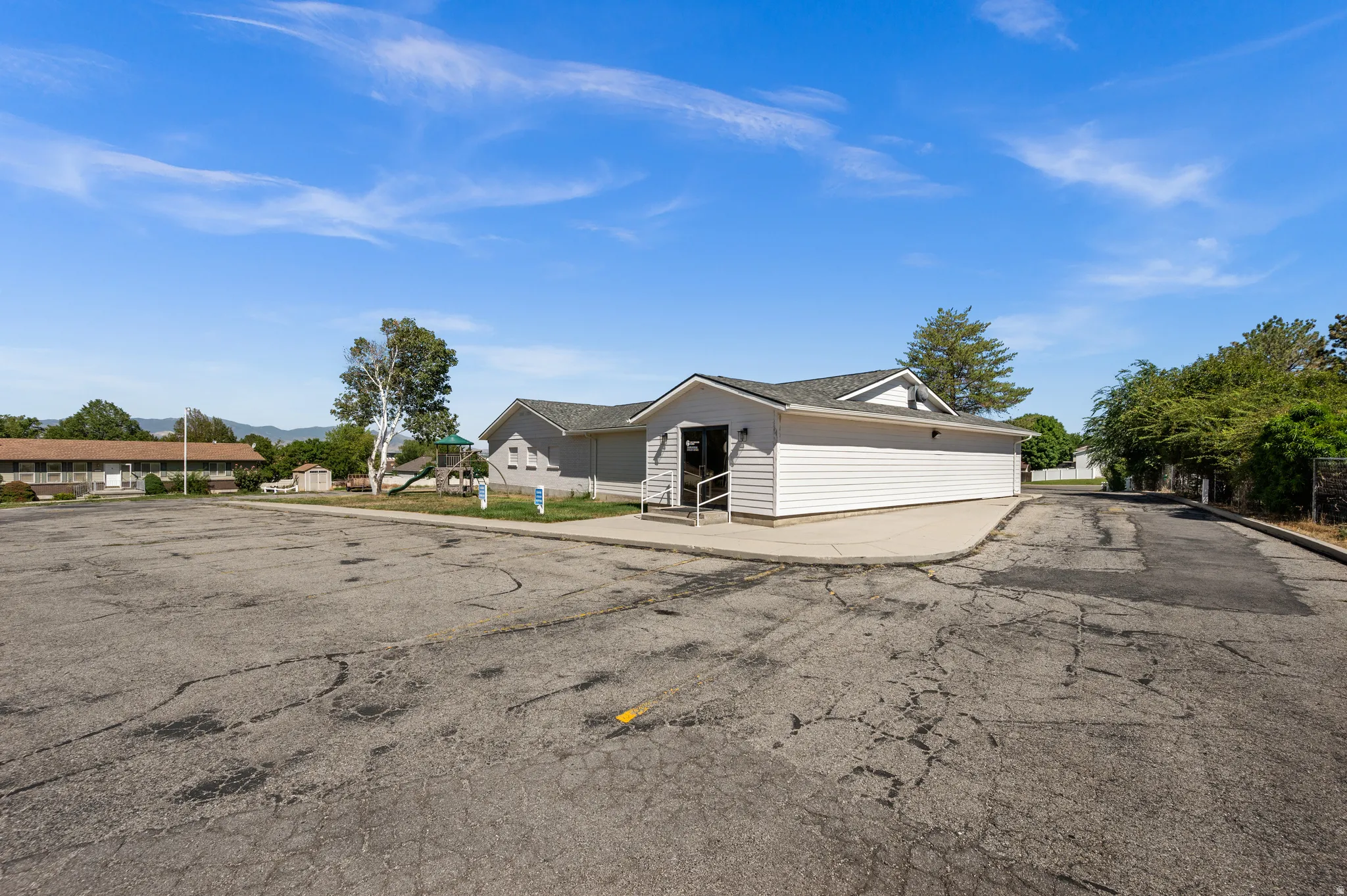Building exterior with white siding and a gray shingle roof