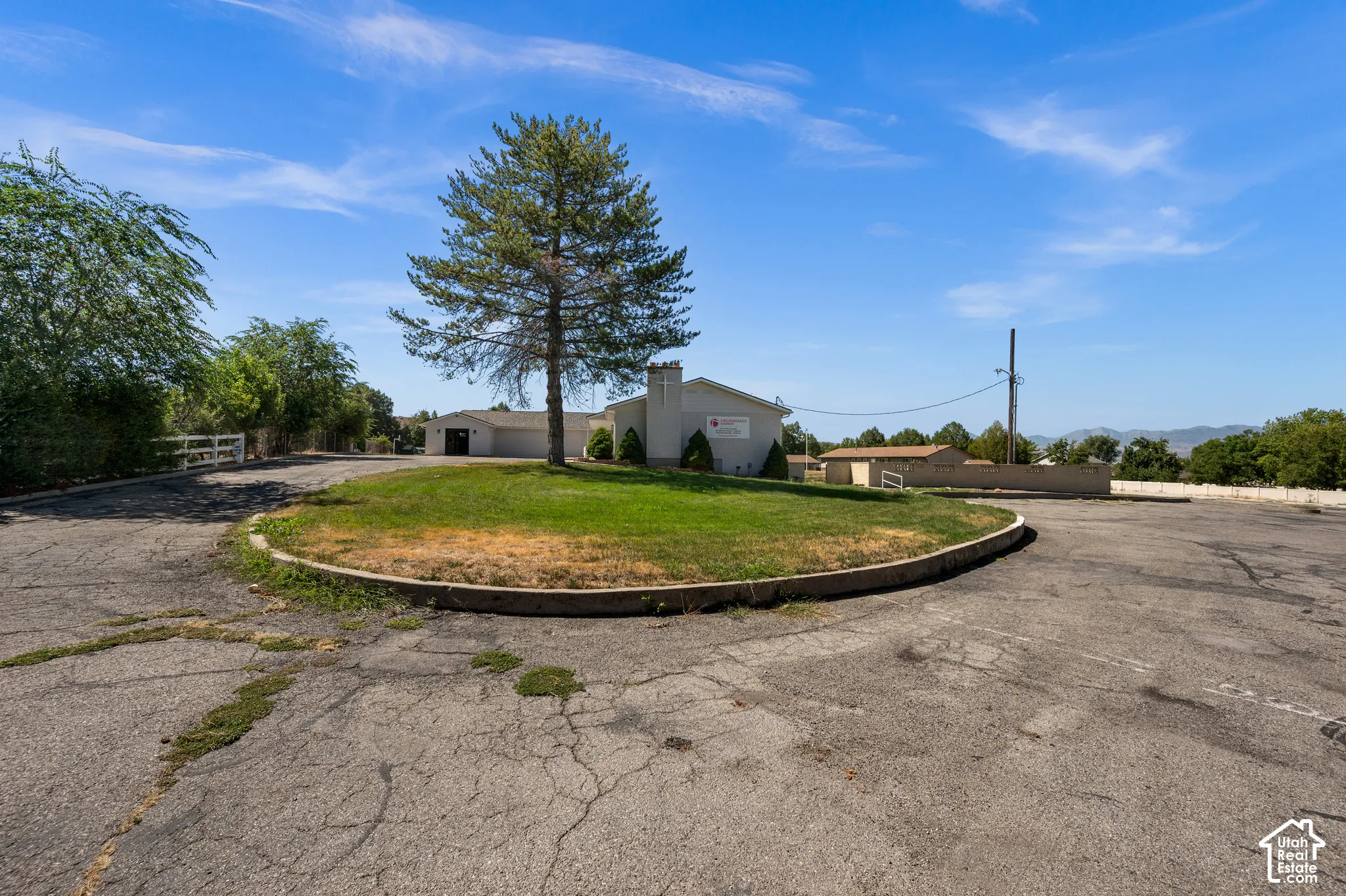 Paved parking area with a central landscaped island and mature trees