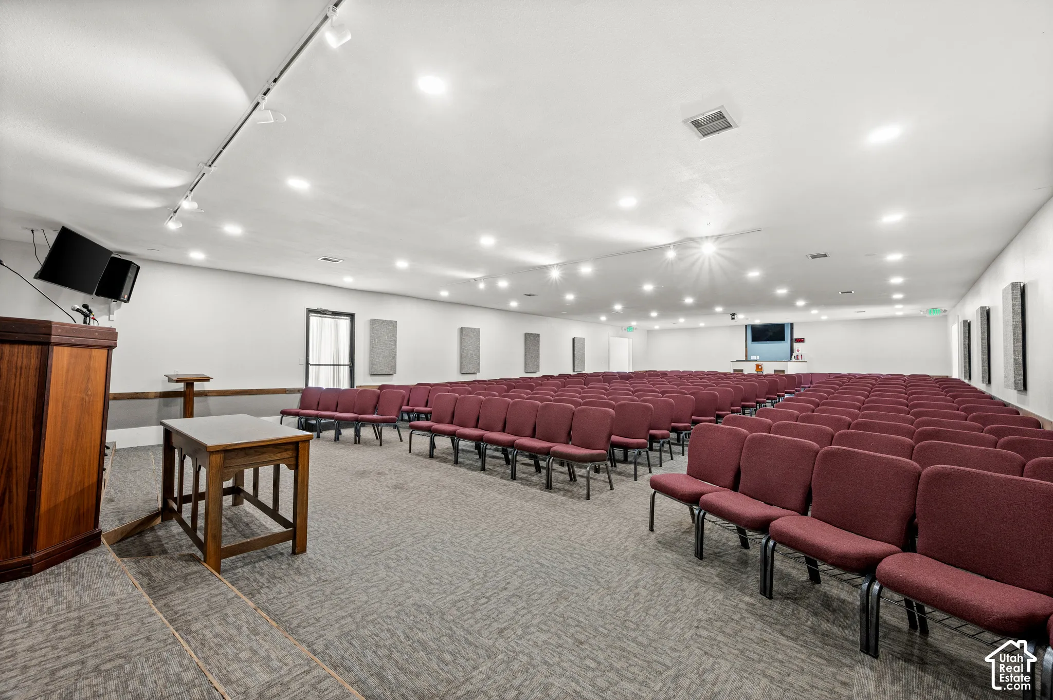 Spacious hall with recessed lighting, track lighting, and wall-mounted acoustic panels