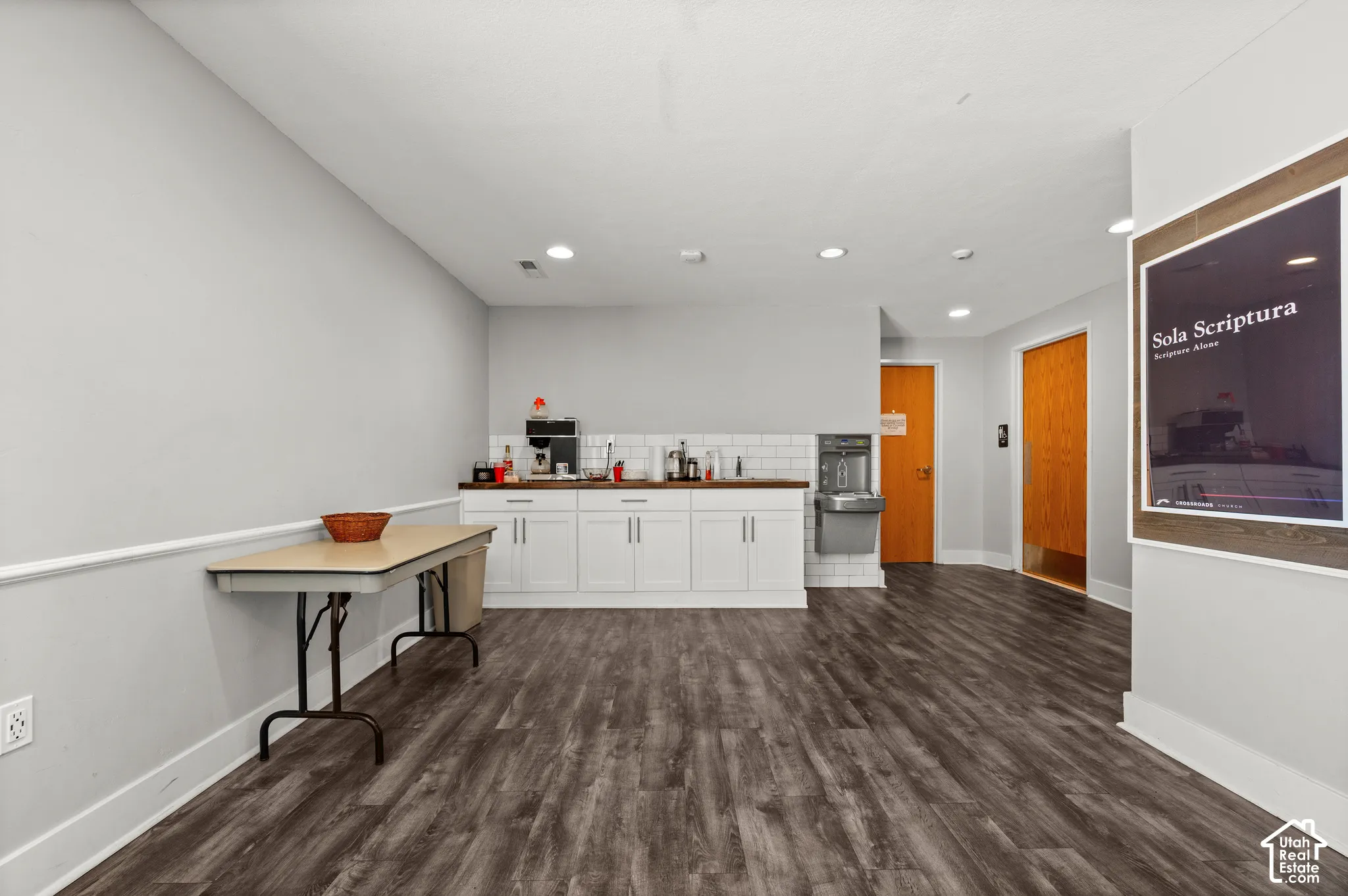 Wood-finish flooring throughout, white baseboards, and neutral wall tones
