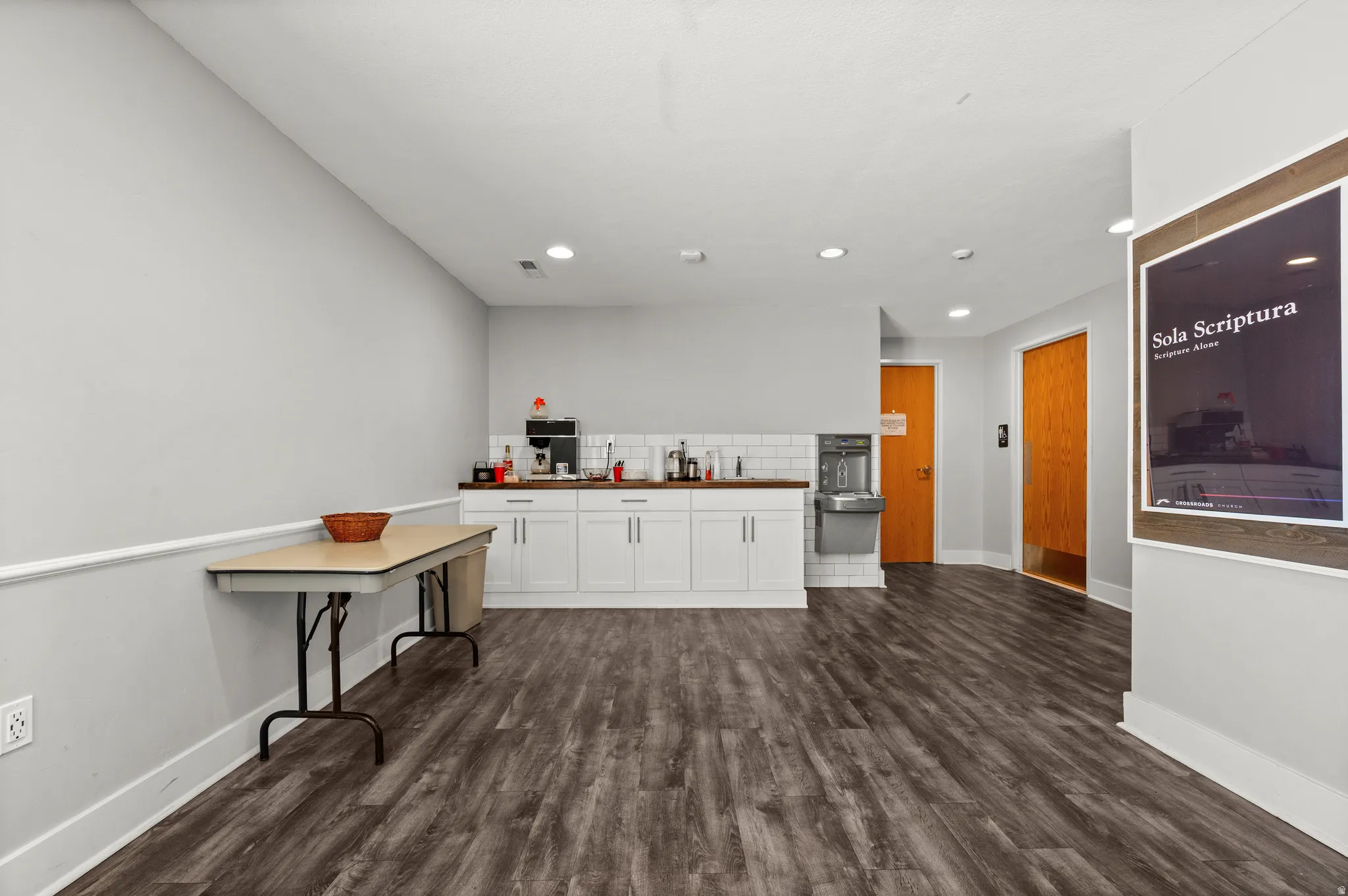 Wood-finish flooring throughout, white baseboards, and neutral wall tones