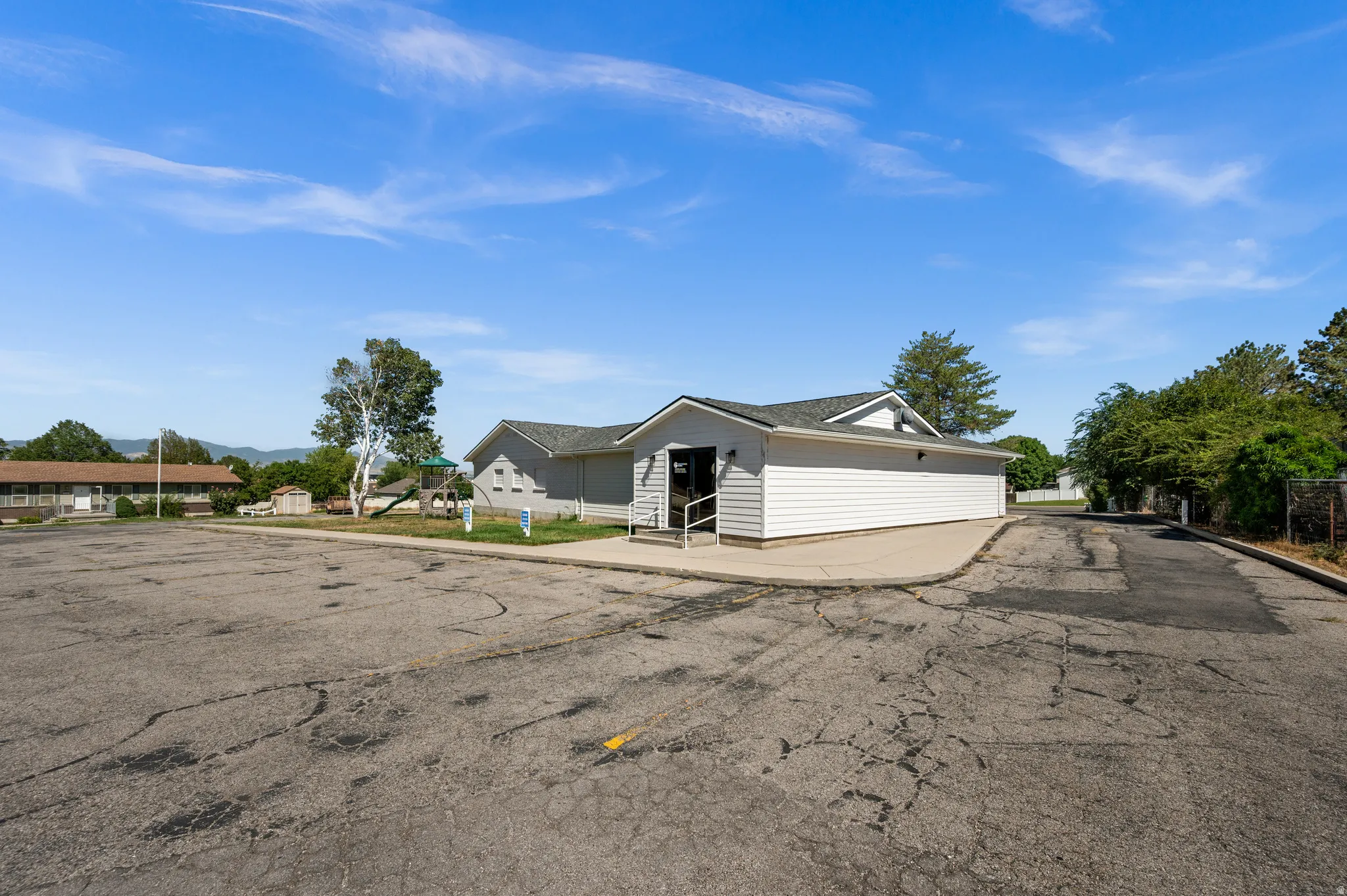 Building with white horizontal siding and a dark shingle roof