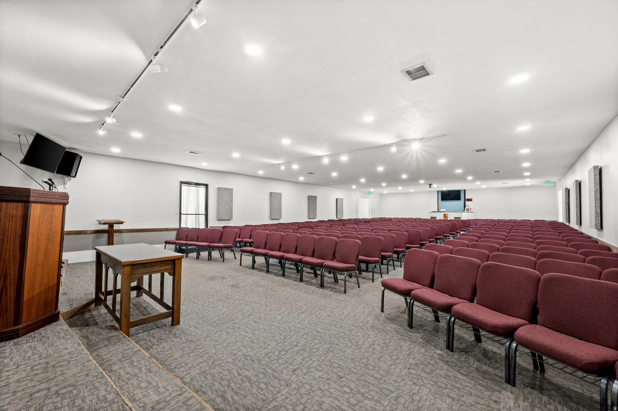 Spacious hall with recessed lighting, track lighting, and wall-mounted acoustic panels