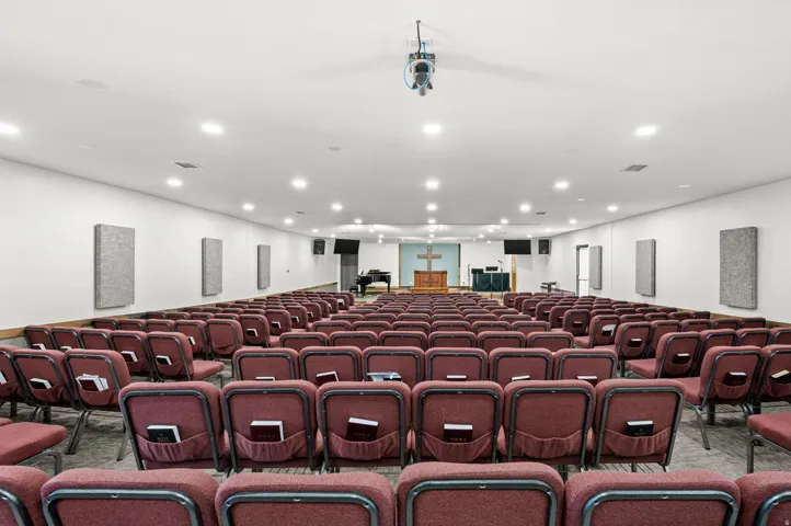 Spacious room with recessed lighting and wall-mounted acoustic panels