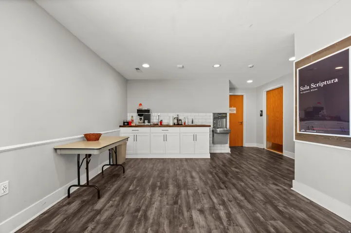 Wood-finish flooring throughout, white baseboards, and neutral wall tones