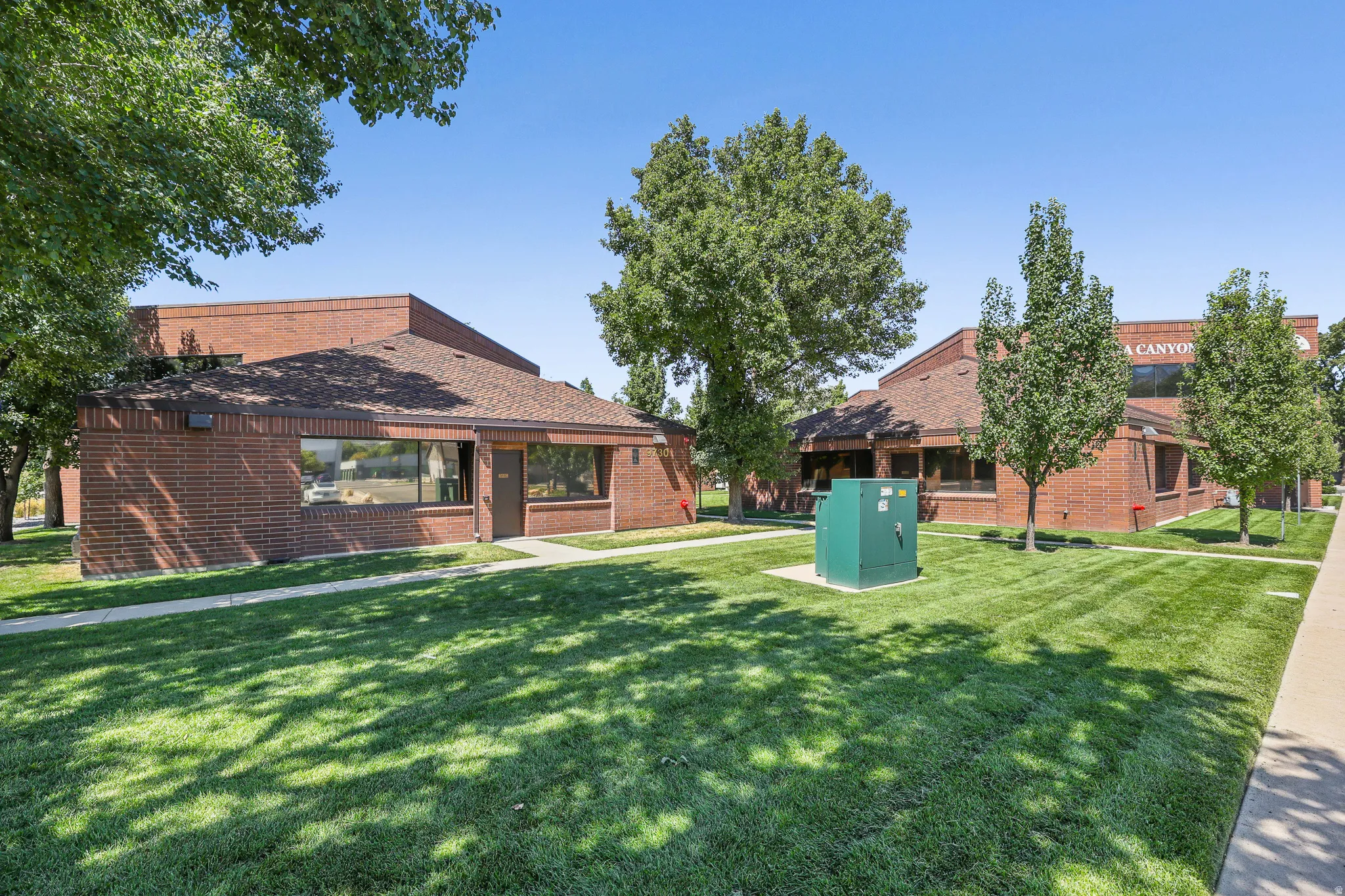 Brick exterior with extensive landscaping and mature trees