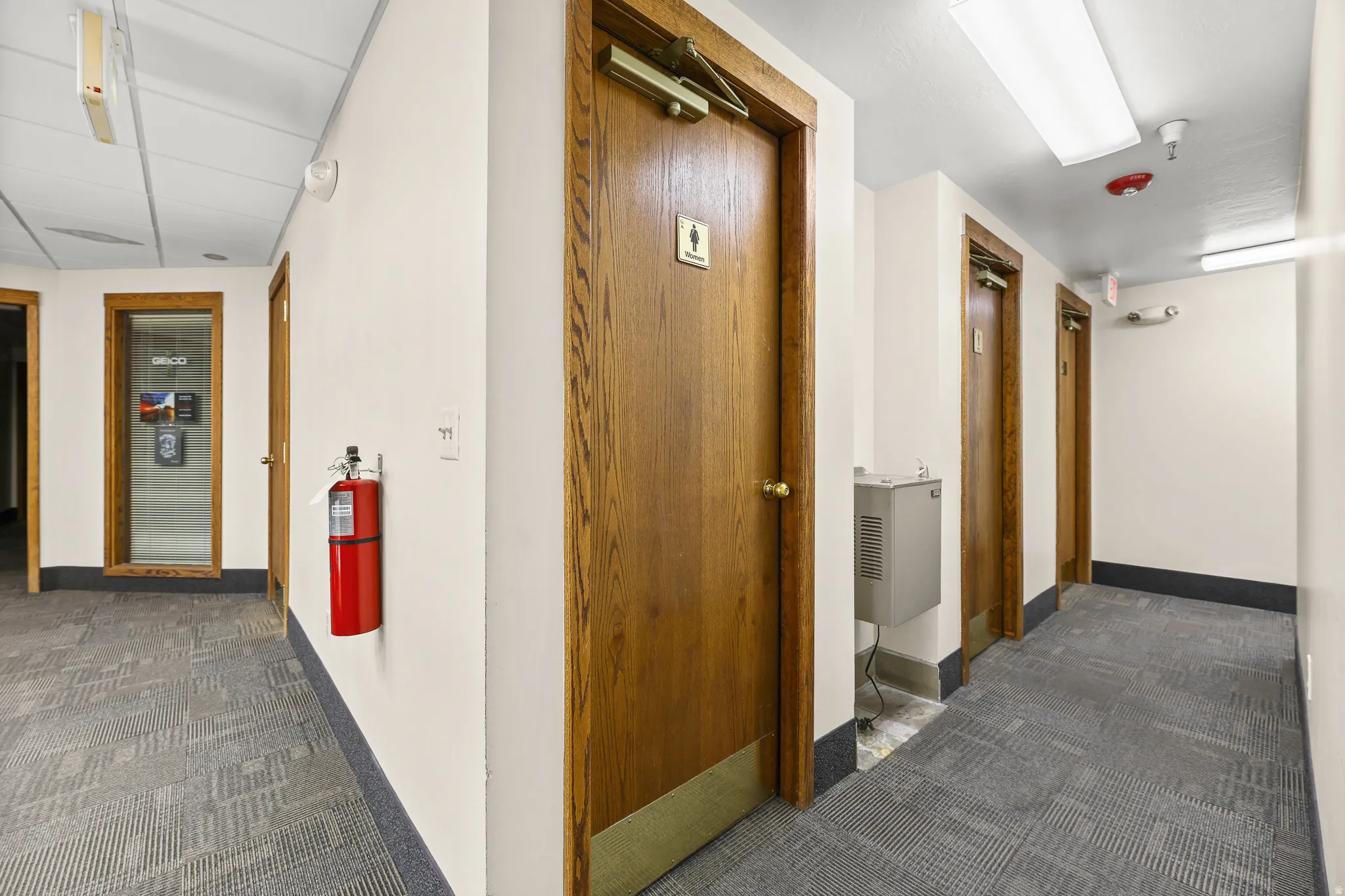 Hallway featuring paneled doors, carpeted flooring, and recessed lighting