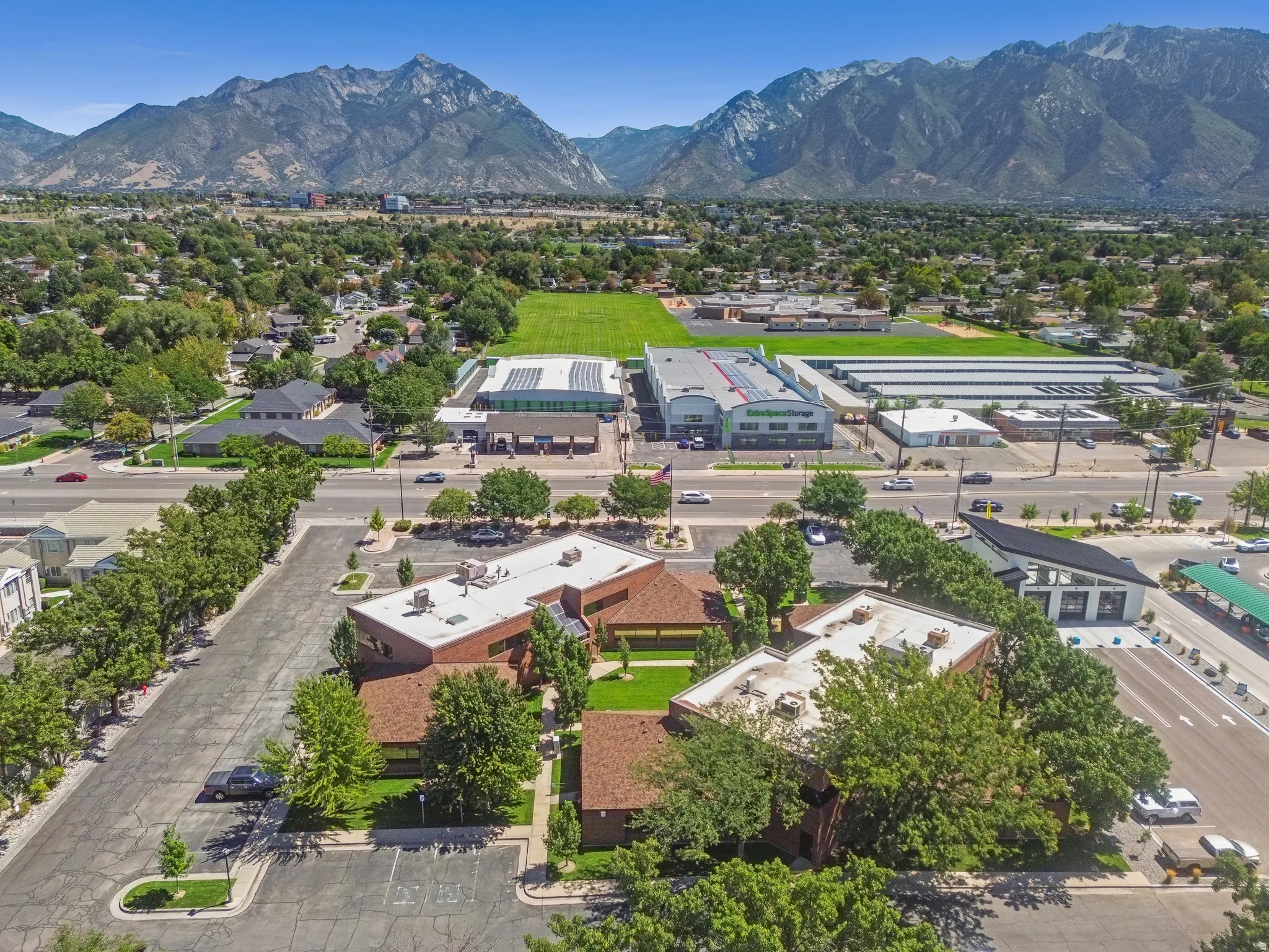 Expansive paved parking lot, mature trees, and landscaping