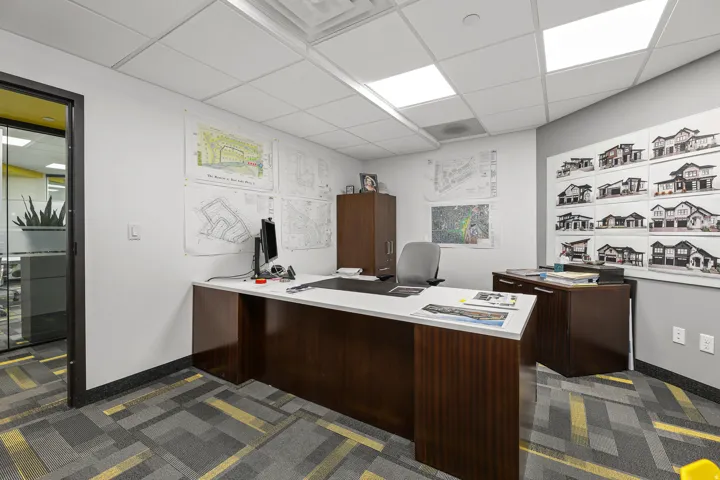 Office space with patterned carpet flooring, recessed lighting, and a glass-paneled entry door