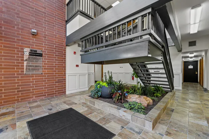 Brick wall detailing, multi-level staircase, wainscoting, tiled flooring, and a built-in planter