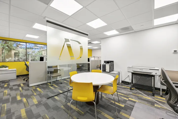 Window-lined office space featuring a suspended ceiling with recessed lighting