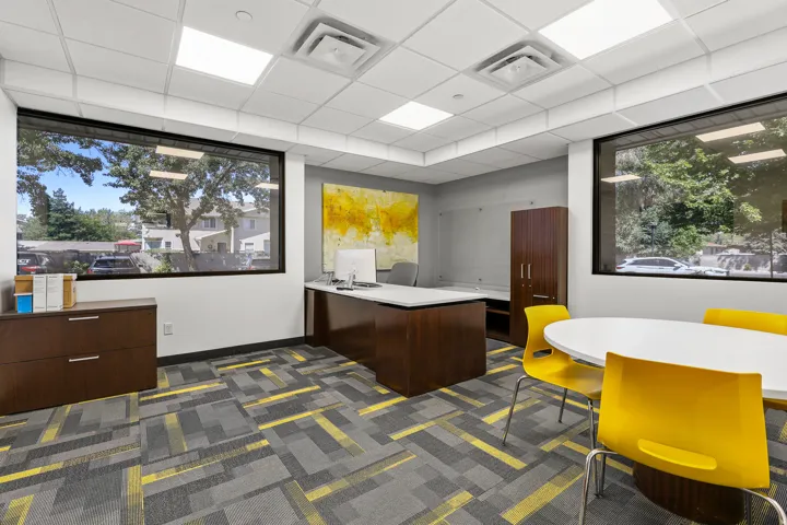 Expansive windows, patterned carpet flooring, recessed lighting, drop ceiling, and built-in cabinetry