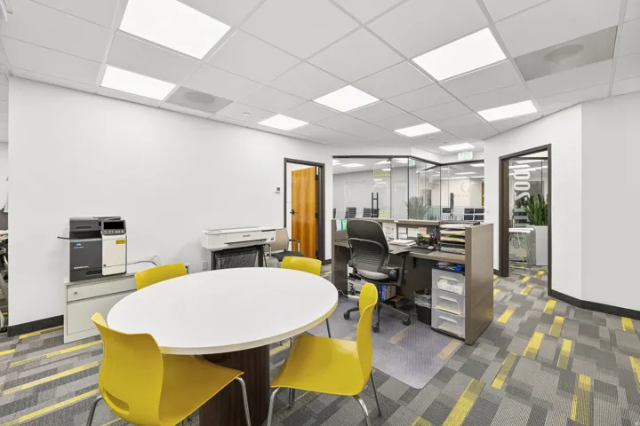 Recessed ceiling lighting, dropped ceiling, wood-finish door, glass partition walls, and patterned carpet flooring