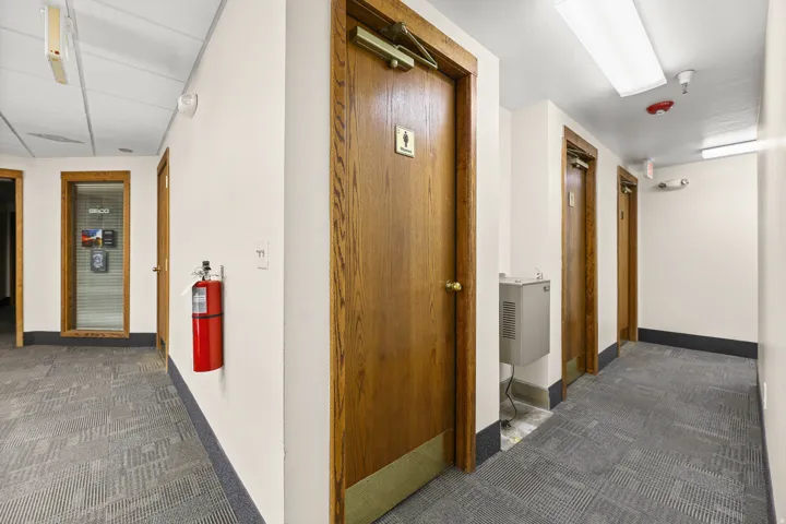 Hallway featuring paneled doors, carpeted flooring, and recessed lighting