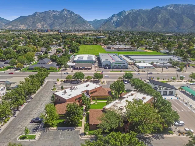 Expansive paved parking lot, mature trees, and landscaping