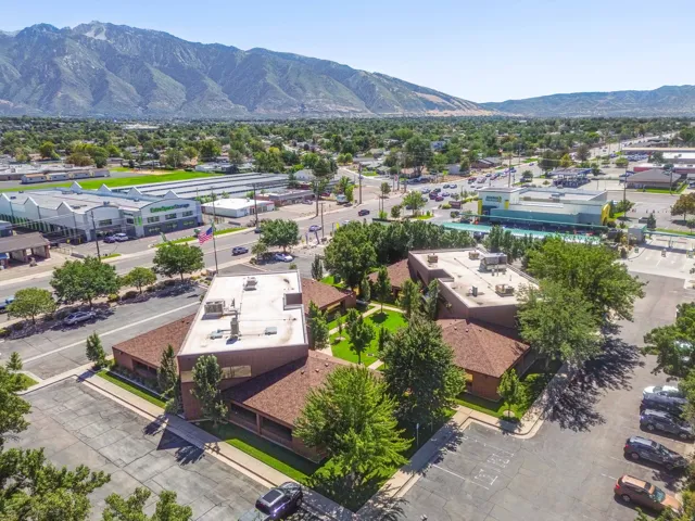 Expansive commercial building with a central courtyard, surrounded by mature trees and paved parking areas