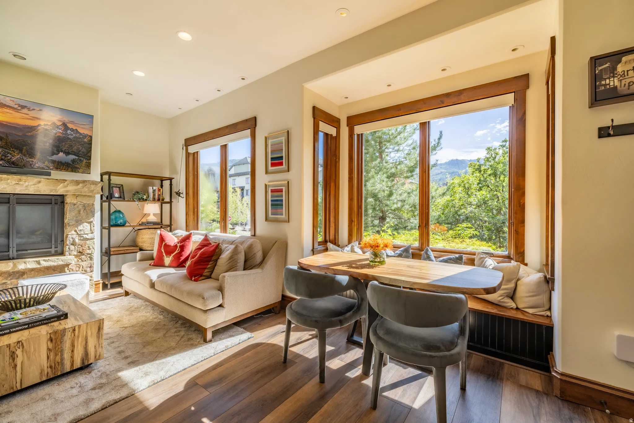 Stone-clad fireplace, built-in window seating, rich wood-finish flooring, recessed lighting, and expansive windows