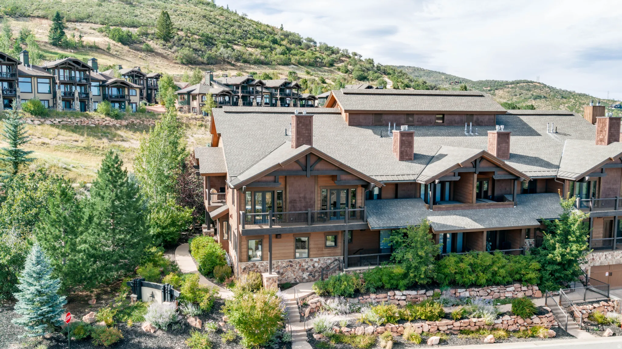 Multi-level residence featuring rustic wood siding and stone accents