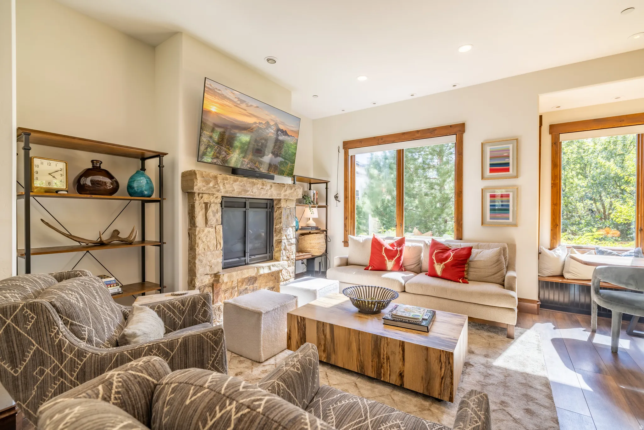Stone-clad fireplace, built-in shelving, wood-trimmed windows, and recessed lighting
