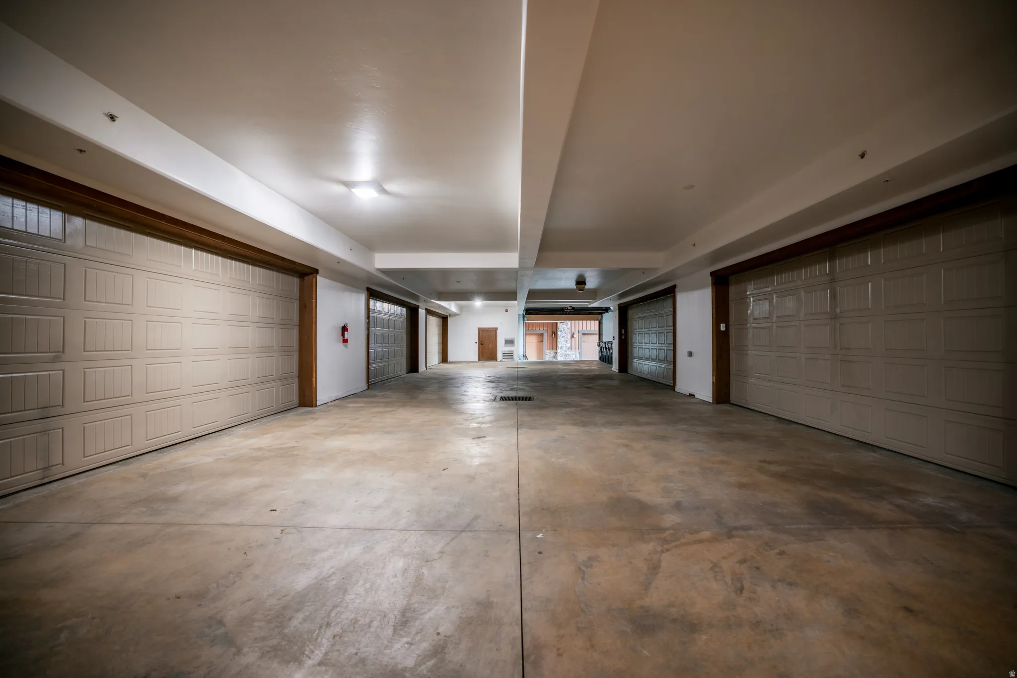 Spacious multi-car garage with multiple overhead doors and concrete flooring