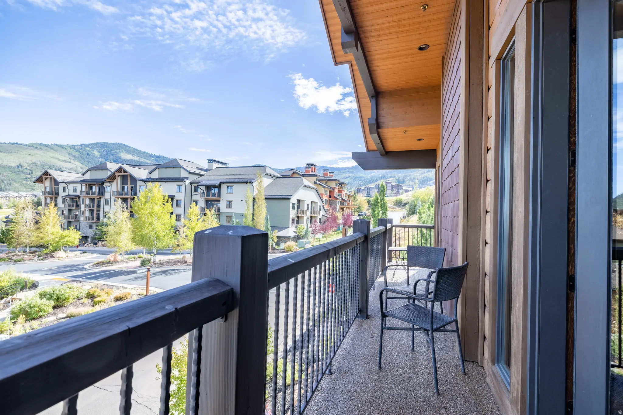 Private balcony featuring a wood-plank ceiling, recessed lighting, and metal railings
