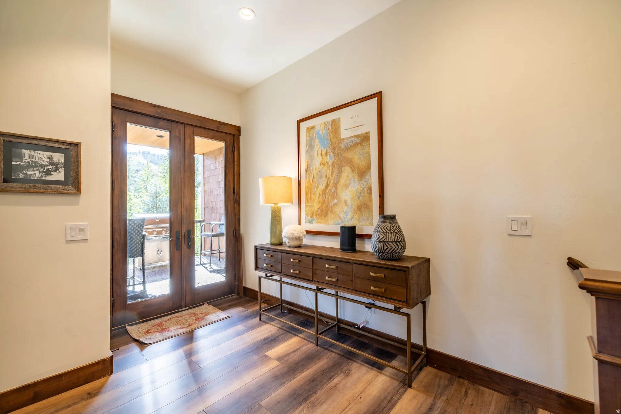 Wood-finish flooring throughout, recessed lighting, and wooden French doors