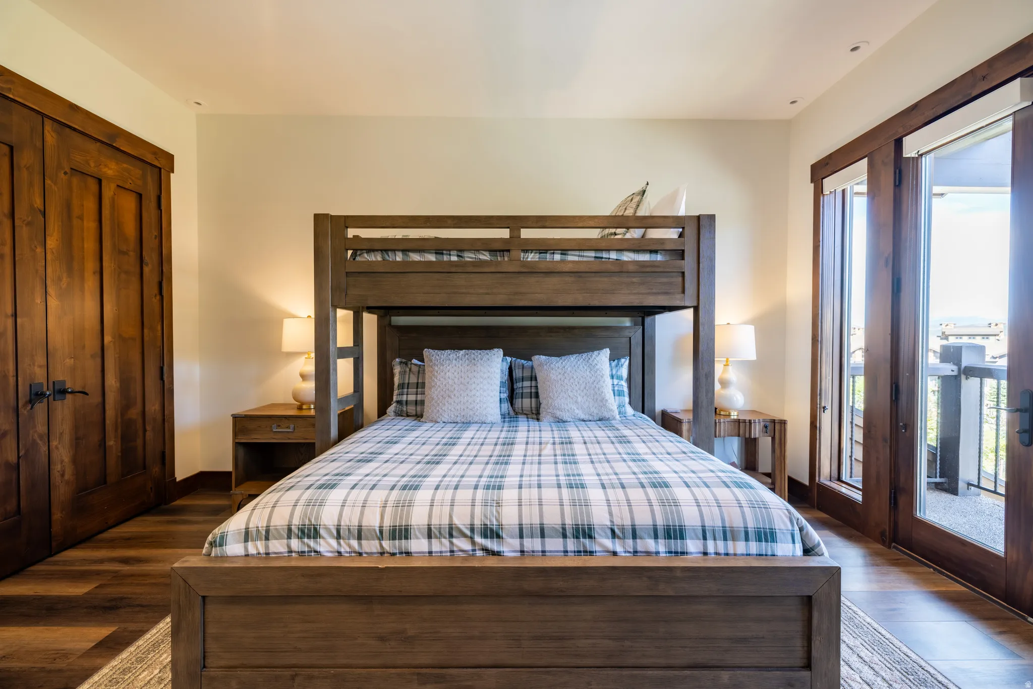 Wood-finish flooring throughout, featuring a natural wood-panel door and a set of French doors with an exterior balcony
