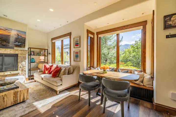 Stone-clad fireplace, built-in window seating, rich wood-finish flooring, recessed lighting, and expansive windows