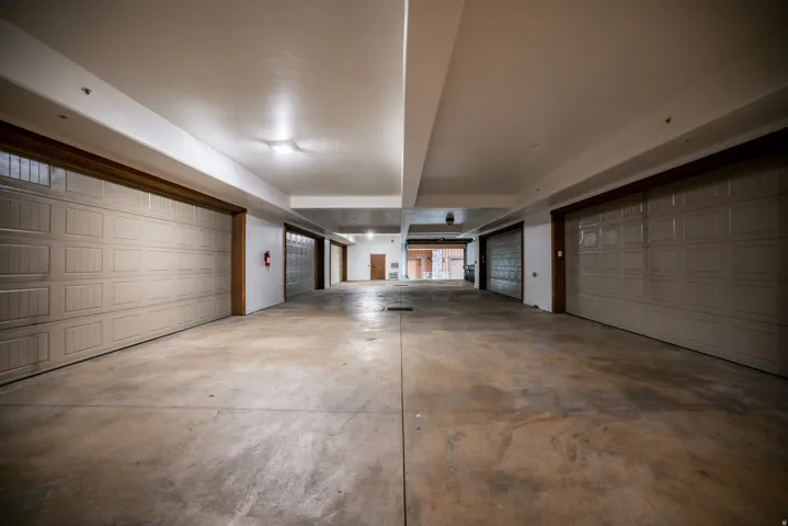Spacious multi-car garage with multiple overhead doors and concrete flooring