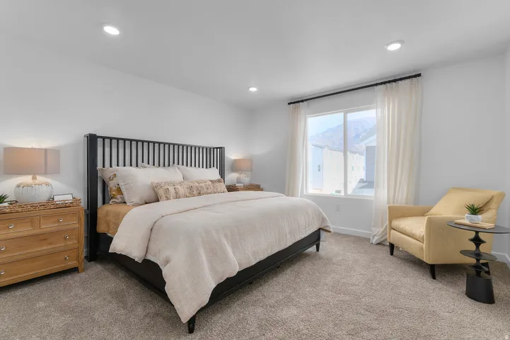 Recessed ceiling lighting, large window with mountain backdrop, and neutral carpet flooring