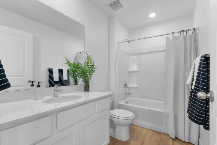 White vanity with an integrated single basin, chrome faucet, and expansive mirror