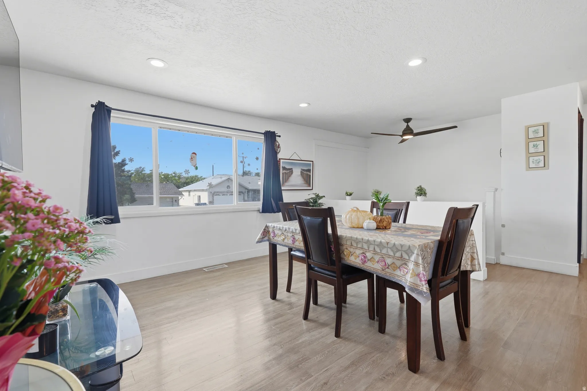 Recessed lighting, wood-finish flooring, and a ceiling fan with integrated lighting