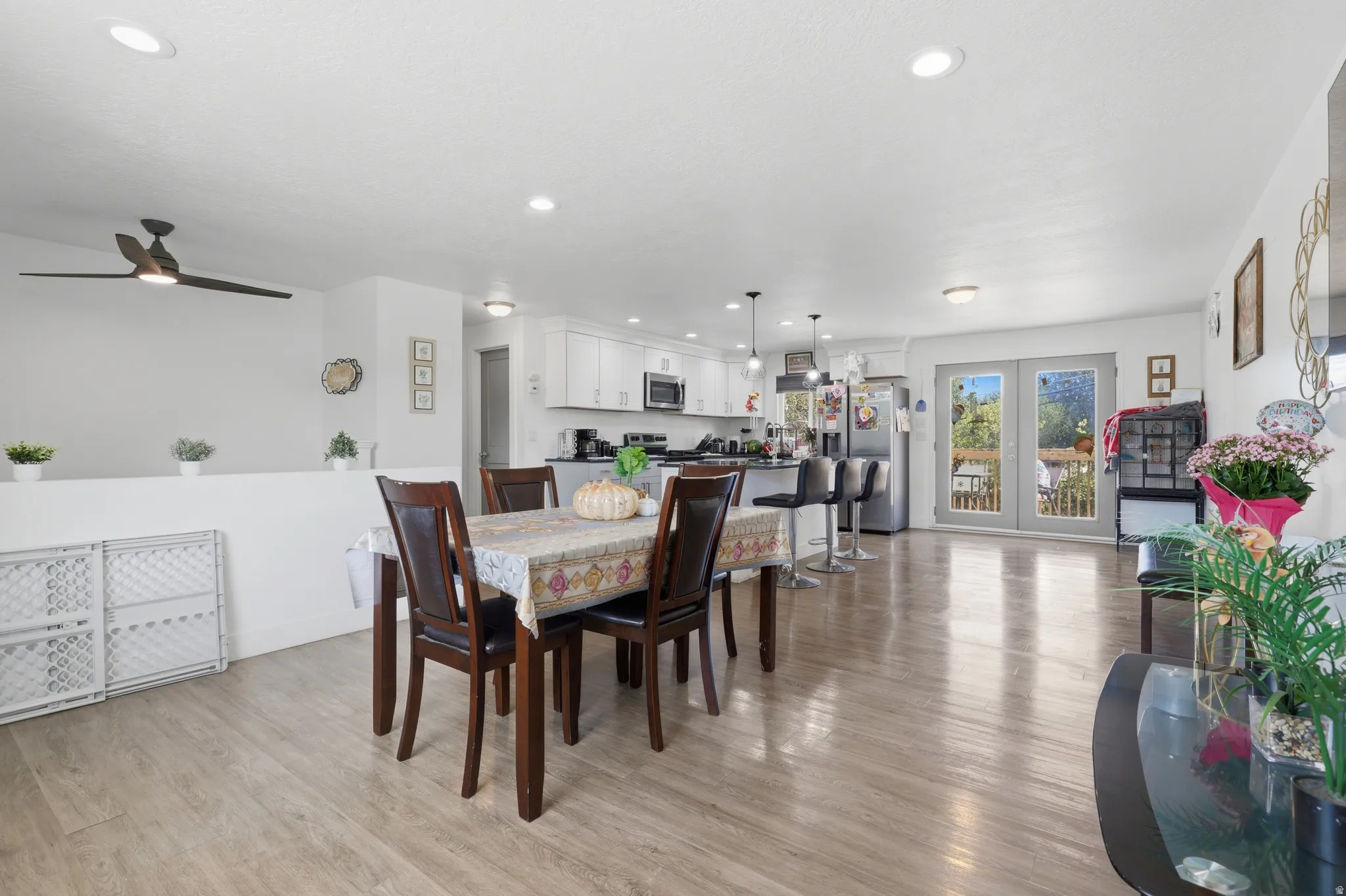 Open-concept living area with wood-finish flooring, recessed lighting, and a ceiling fan