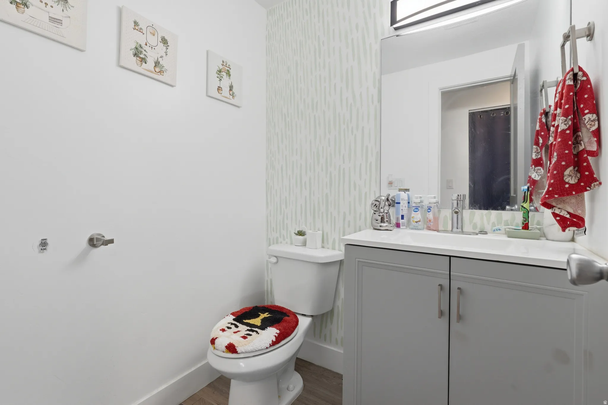 Vanity with a solid surface countertop, undermount sink, and wood-finish flooring