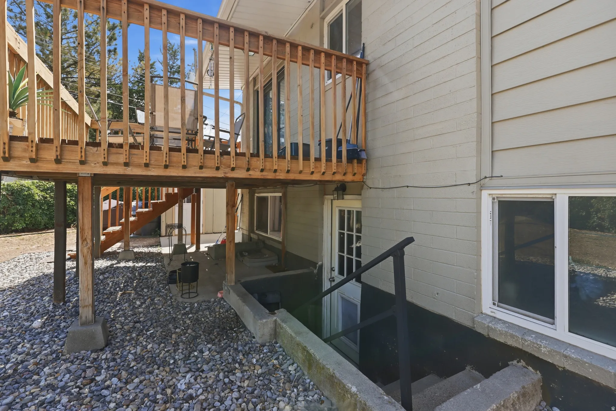 Expansive wood deck with baluster railing, offering access to a sliding glass door