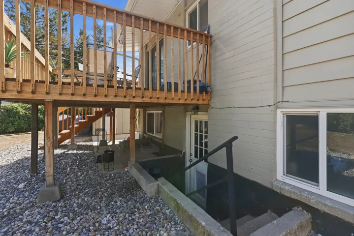 Expansive wood deck with baluster railing, offering access to a sliding glass door