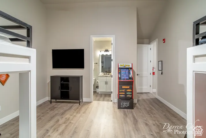 Neutral-toned room featuring wood-finish flooring, high ceilings, and white paneled interior doors
