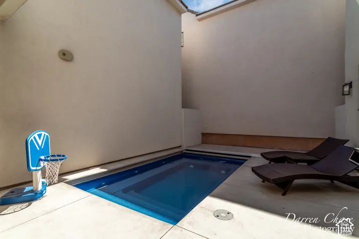 Private courtyard featuring a plunge pool with concrete decking and high exterior walls