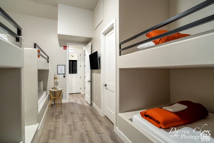 Built-in bunk beds featuring matte black metal railings, wood-finish flooring, and recessed wall niches