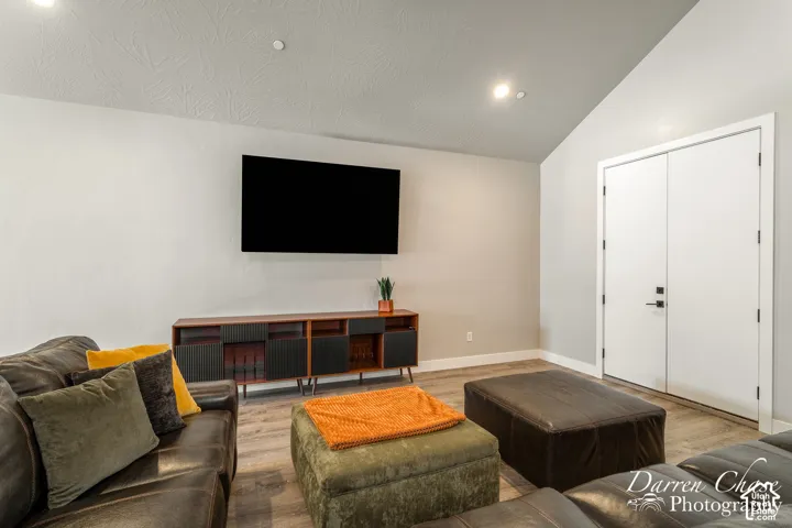Vaulted ceiling, wood-finish flooring, and double doors with matte black hardware